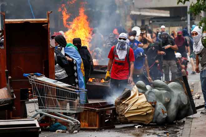  Perabot rosak dilihat di atas jalan raya selepas penunjuk perasaan menjarah sebuah gereja ketika protes antikerajaan di Santiago, Chile kelmarin. — Gambar Jorge Silva/Reuters