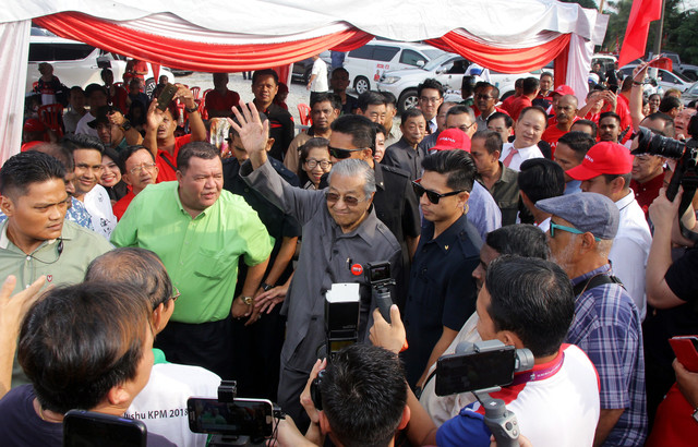 Dr Mahathir  melambaikan tangan kepada orang ramai ketika hadir bersarapan pagi bersama penduduk setempat dan NGO Parlimen Tanjung Piai di Warung 800, Pekan Nanas, hari ini. - Gambar Bernama 