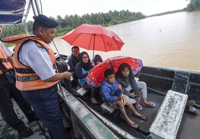 Muhd Nur (kiri) menasihati sebahagian penduduk agar memakai jaket keselamatan ketika menaiki bot pada Program Pertemuan APMM Kelantan Bersama Penduduk di Pulau Muara Sungai Kelantan Untuk Persiapan Banjir semalam. — Gambar Bernama