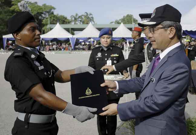   Alwi Ibrahim (kanan) menyampaikan Anugerah Kadet Terbaik Anugerah Ketua Pengarah Imigresen Amirul Fauzan Hassan Zaim (kiri) pada Majlis Perbarisan Tamat Latihan Kursus Asas Pegawai Imigresen Gred KP 19 Siri 3 2019 di Akademi Imigresen Malaysia, semalam. — Gambar Bernama