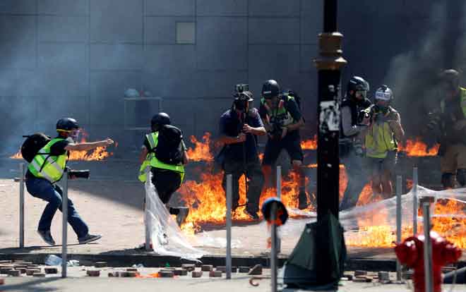  Para wartawan dan jurugambar terkejut apabila dilontar dengan koktel Molotov ketika penunjuk perasaan bertelingkah dengan polis antirusuhan di luar PolyU di Hong Kong, semalam. — Gambar Reuters