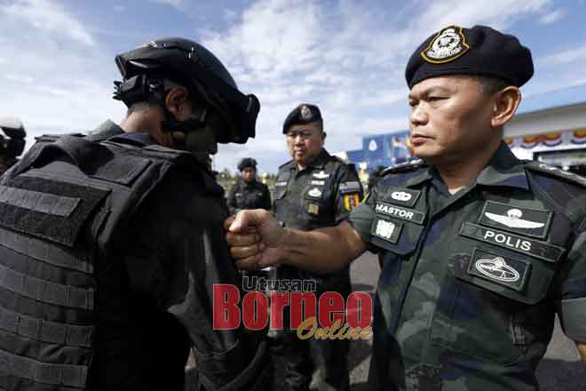  Mastor menyemat lencana kepada salah seorang anggota Tiger Platoon Briged Sarawak PGA yang menamatkan latihan semalam. Turut kelihatan Khaw. — Gambar Chimon Upon 