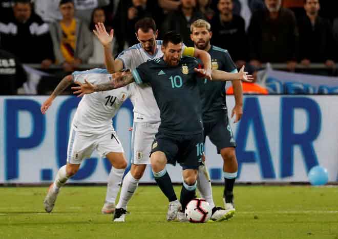  Messi (depan) diasak hebat oleh Godin ketika bersaing pada perlawanan persahabatan di Stadium Bloomfield, Tel Aviv kelmarin. — Gambar AFP