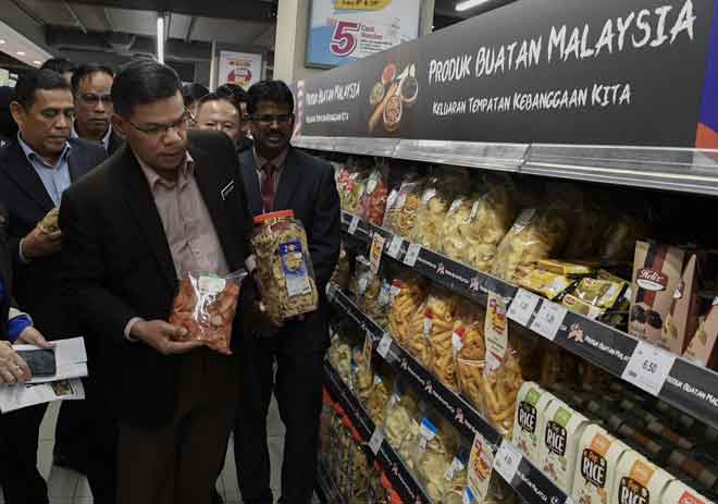   Datuk Seri Saifuddin (tengah) melihat produk Industri Kecil dan Sederhana (IKS) yang turut dijual di pusat beli-belah AEON Taman Maluri selepas merasmikannya semalam. — Gambar Bernama