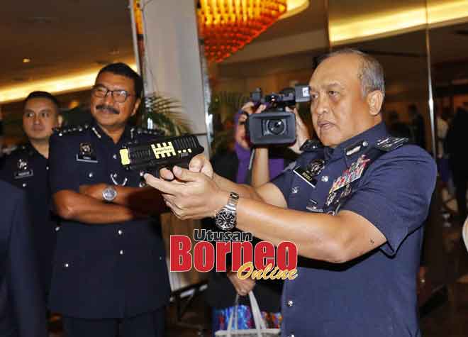  Rosli mencuba pistol di salah sebuah gerai pameran yang dilawatinya pada Majlis Penutupan Persidangan Tahunan Persatuan Polis Bantuan Malaysia Ke-13 di Kuching, semalam.