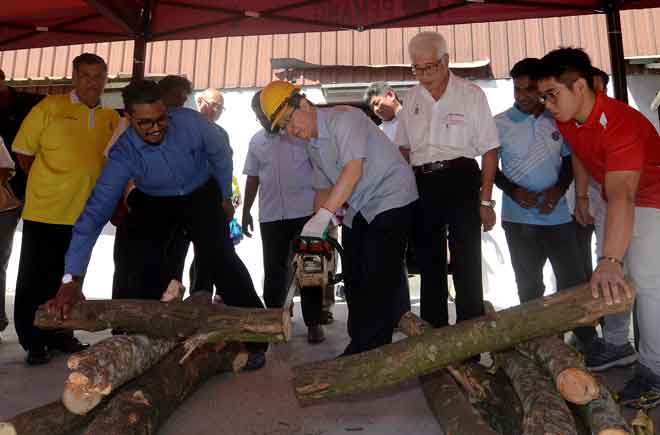  Lim memotong dahan pokok menggunakan mesin gergaji berantai (chainsaw) pada Program Latihan Pengurusan Krisis dan Sumbangan Mesin Chainsaw Kawasan Parlimen Bagan semalam.  — Gambar Bernama
