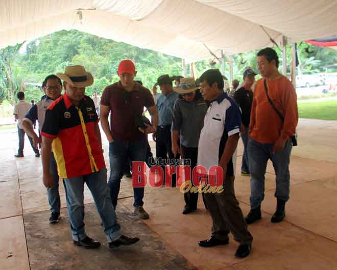  Henry (kiri) meninjau persiapan di Dataran Bazaar Krokong, Bau semalam bagi majlis bersama Ketua Menteri, Sabtu ini. 