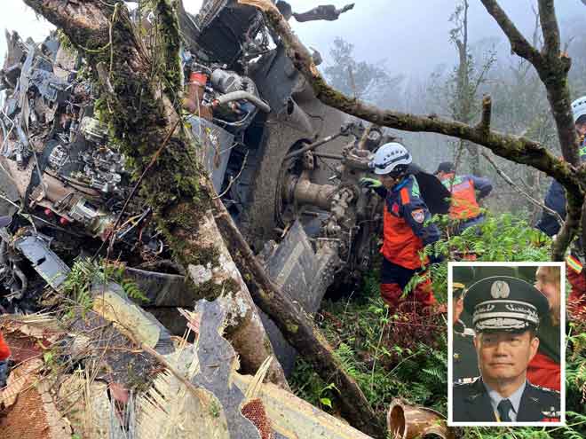  Gambar serahan Jabatan Bomba Daerah Yilan semalam menunjukkan anggota bomba memeriksa bangkai helikopter yang terhempas di gunung di Yilan dekat Taipei, Taiwan dan membunuh beberapa orang termasuk Shen (sisipan). — Gambar AFP
