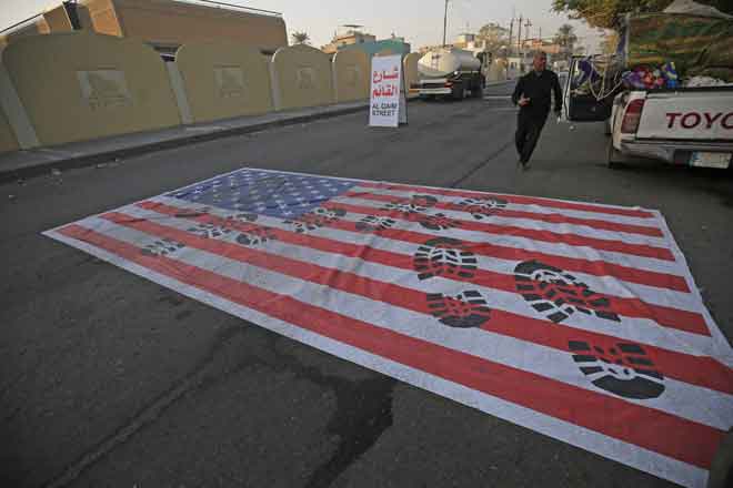  Bendera olok-olok AS dibentangkan di atas jalan raya di Baghdad, Iraq semalam ekoran kematian komander tertinggi Iran dalam serangan AS ke atas konvoinya di Lapangan Terbang Antarabangsa Baghdad. — Gambar Ahmad Al-Rubaye/AFP