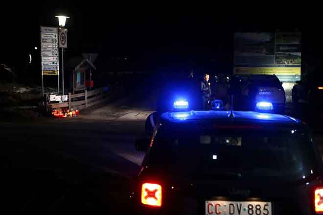  Seorang wartawan membuat liputan berdekatan kereta ‘carabinieri’ Itali dengan lilin dan jambangan bunga diletakkan di tempat kejadian di Via Aurina SS 621, Lutago, Tyrol Selatan kelmarin. — Gambar AFP