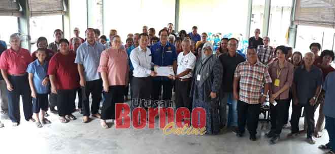  Bujang (enam kiba) benung nyuaka dokumen Balai Mensia Mayuh ngagai Tuai Rumah Lichang (enam kanan) seraya dikemataka Harden (tengah) enggau ke bukai.