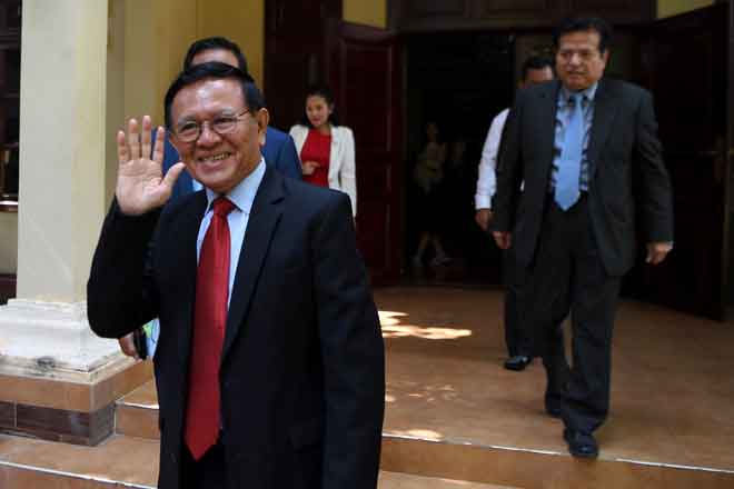  Kem Sokha mengangkat tangan kepada anggota media ketika meninggalkan                     kediamannya untuk menghadiri perbicaraan atas tuduhan derhaka di mahkamah Phnom Penh, Kemboja semalam. — Gambar AFP