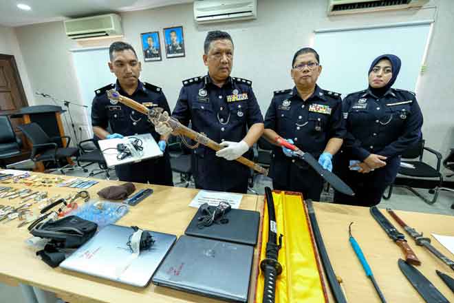  A Asmadi (dua kiri) menunjukkan pedang pelbagai jenis yang dirampas daripada suspek kes pecah rumah di sekitar kawasan Medan Pasir pada sidang media di Ibu Pejabat Polis Daerah (IPD) Ipoh, semalam. — Gambar Bernama