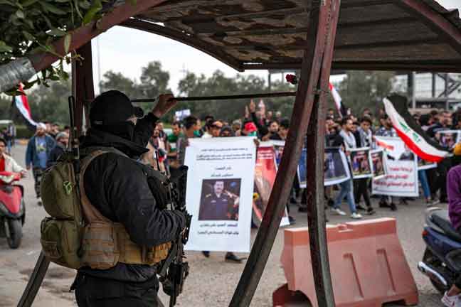 Anggota polis mengawasi penunjuk perasaan yang berarak semasa protes antikerajaan, turut menggesa untuk kebebasan media, di bandar Basra di selatan Iraq kelmarin. — Gambar AFP