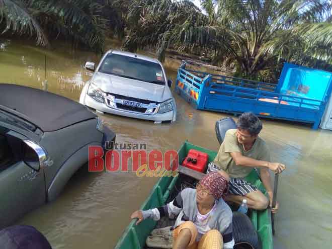  Penduduk kampung memantau keadaan beberapa kenderaan yang terkandas akibat banjir di ladang sawit tersebut. 