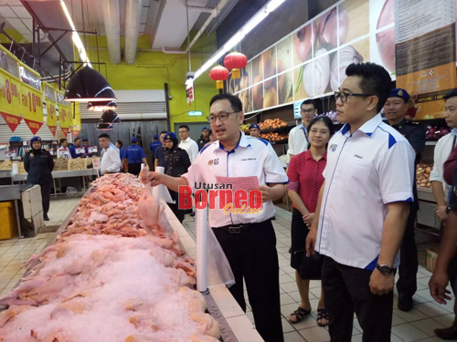 Chong memeriksa harga ayam yang dijual di Pasaraya Emart Batu Kawa, Kuching hari ini dibawah SHMMP Tahun Baru Cina 2020. Turut kelihatan Stanley (kanan).