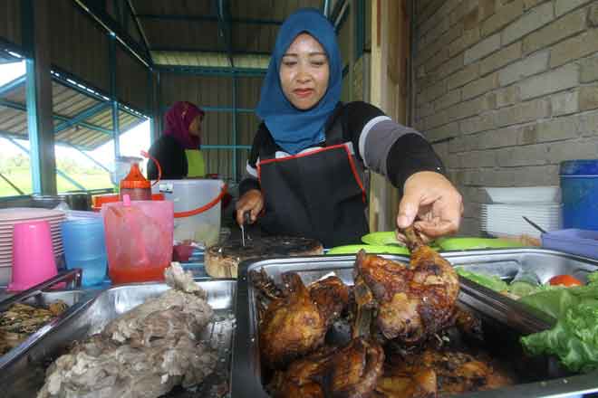  Salah seorang pekerja sibuk menyediakan menu RM1 di warung milik Zulkifli semalam. — Gambar Bernama