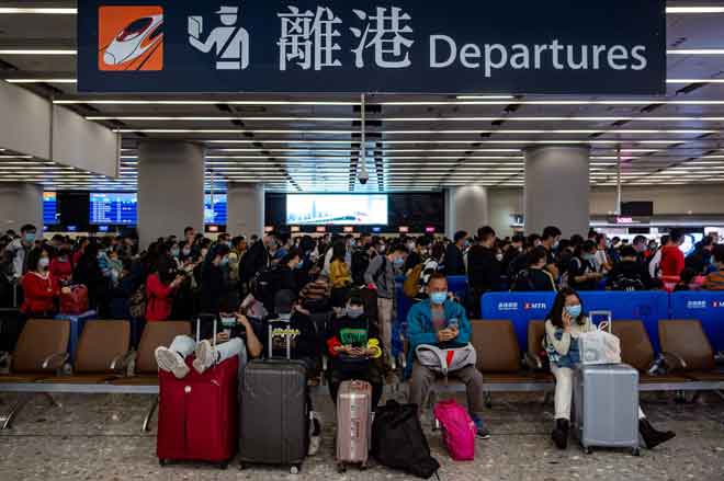  Orang ramai memakai topeng perlindungan berbaris di balai berlepas stesen kereta api Kowloon Barat di Hong Kong, semalam. — Gambar AFP