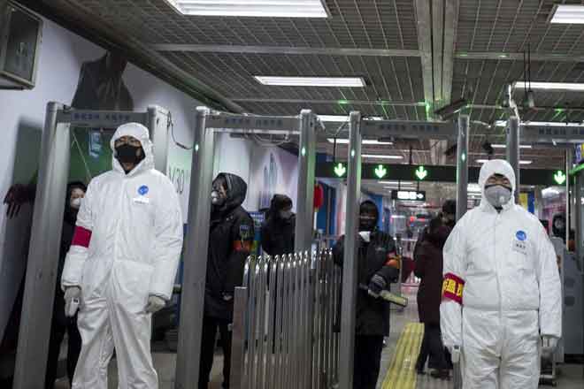  Anggota keselamatan memakai sut perlindungan untuk membantu menghentikan penyebaran virus maut yang bermula di Wuhan, berkawal di sebuah stesen kereta api bawah tanah di Beijing, kelmarin. — Gambar AFP