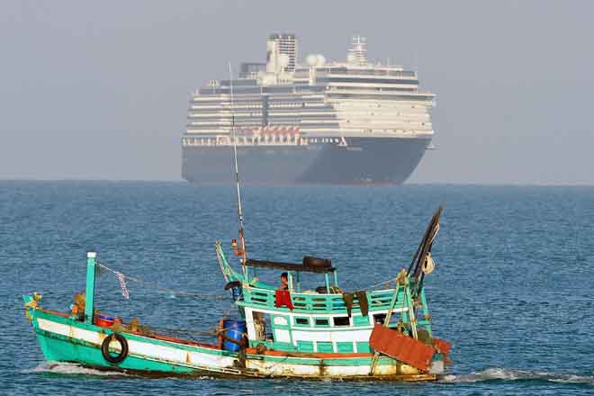  Kapal persiaran Westerdam dilihat melintasi sebuah bot nelayan ketika ia menghampiri pelabuhan         di  Sihanoukville, di pantai selatan Kemboja semalam di mana ia telah menerima kebenaran untuk berlabuh selepas ditolak                           di beberapa pelabuhan Asia lain kerana kebimbangan mengenai jangkitan COVID-19 di atas kapal tersebut. — Gambar AFP 