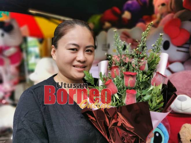 Helen menjual pelbagai gubahan bunga di gerainya di Tebingan Kuching sempena Hari Kekasih. Gambar Roystein Emmor