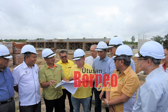 Dr Sim (lima dari kiri) diberi penerangan oleh wakil dari HDC mengenai pelaksaan dua projek jalan masuk di Sibu Jaya sambil diperhatikan oleh yang lain.