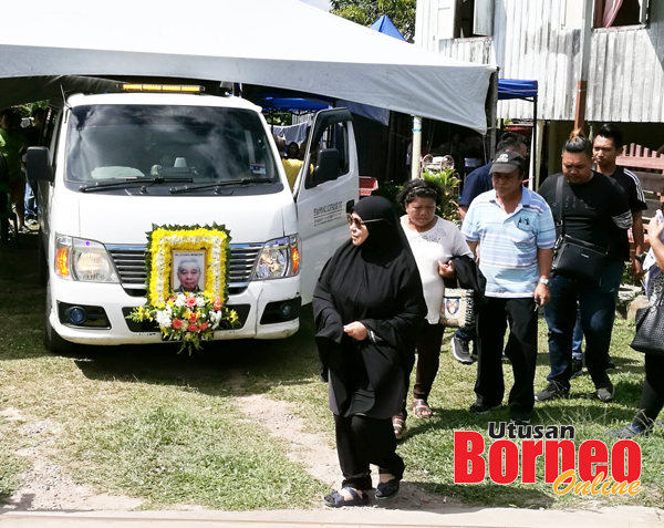  Anak perempuan mendiang yang beragama Islam berjalan di hadapan kereta jenazah bapanya.