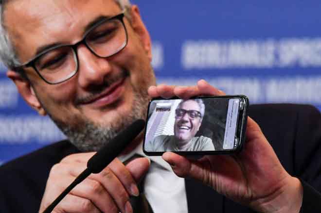  Produser Farzad Pak memegang telefon yang menunjukkan pengarah Mohammad Rasoulof yang dianugerahkan dengan ‘Golden Bear for Best Film’ semasa sidang media selepas majlis anugerah  festival filem Berlinale ke-70 di Berlin pada 29 Februari lepas. — Gambar AFP