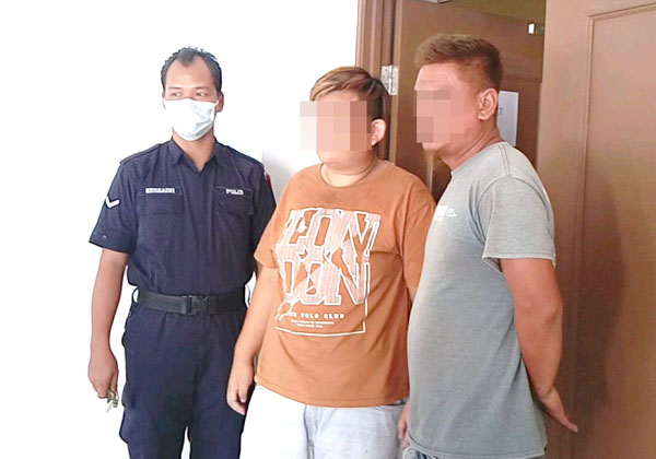  Polis mengiringi Yong (tengah) dan Injimar keluar dari kamar mahkamah selepas selesai prosiding.
