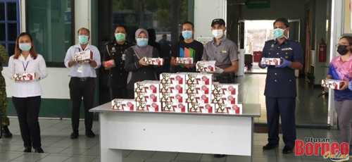 Pihak polis dan pekerja perkhidmatan awam di Pejabat Daerah Limbang bergambar bersama set KFC masing-masing.