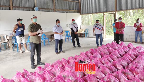  Madius (kiri) bersedia menyampaikan bantuan makanan kepada wakil penerima.