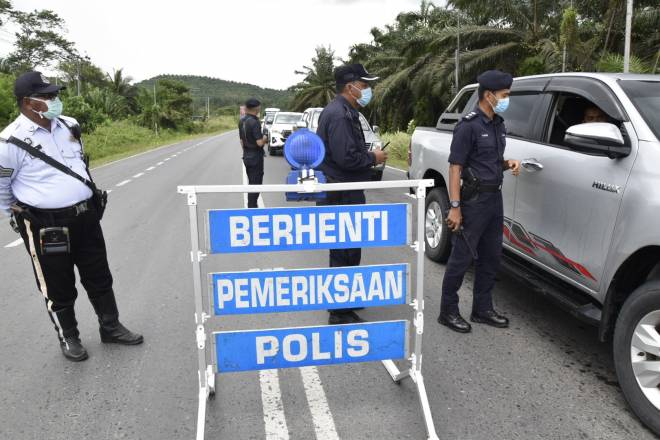 Gambar fail menunjukkan polis melakukan sekatan jalan raya Perintah Kawalan Pergerakan.