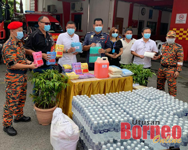 Tiong (empat kiri) bersama Wee (tiga kiri) dan Ong (dua kiri) semasa menyampaikan sumbangan di Balai Bomba dan Penyelamat Padungan, hari ini.