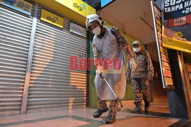  Anggota bomba melakukan sanitasi awam di tengah bandar Limbang, malam kelmarin.