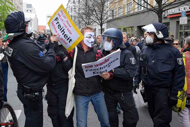  Anggota polis bertelingkah dengan seorang penunjuk perasaan antisekatan COVID-19 di Berlin, kelmarin.  — Gambar AFP
