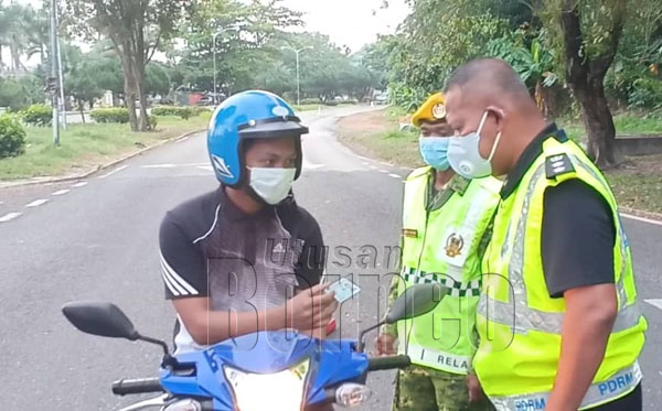  Mohd Azhar memeriksa penunggang motorsikal yang melalui Sekatan Jalan Raya.