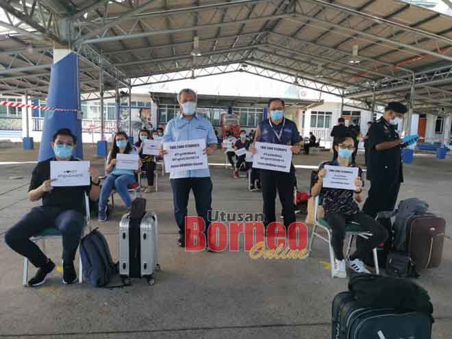  Naib Canselor UNIMAS Profesor Datuk Dr Mohamad Kadim Suaidi (berdiri, kiri) bersama pegawai UNIMAS yang lain dan sebahagian daripada pelajar yang dihantar balik kampung semalam. 