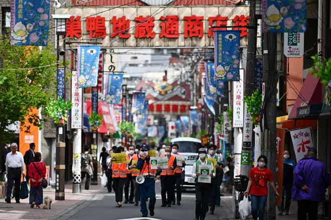  Pekerja perbandaran meronda sebatang jalan sambil meminta orang ramai untuk duduk di rumah semasa wabak COVID-19 di Tokyo, semalam. — Gambar AFP