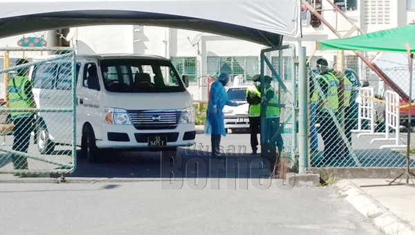  Kakitangan KKM menunjukkan dokumen PUI yang hendak di kuarantin di Pusat Kuarantin Sandakan ketika melalui kawalan ketat polis di PPR Taman Harmoni.