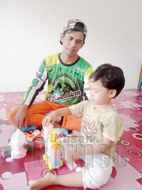 Mohd Dasmin bersama salah seorang anaknya menyusun alat permainan ketika berada dalam rumah.