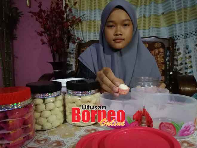  Anak Suria, Aizatul Nabila, 13, mengisi balang dengan biskut raya untuk dinikmati mereka sekeluarga pada Aidilfitri nanti.