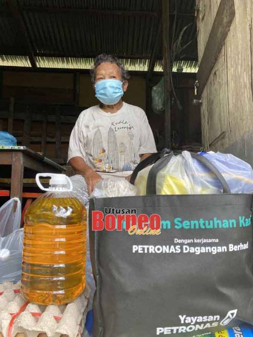  Sedi merakamkan gambar bersama bantuan makanan yang diterima dari Program Sentuhan Kasih Petronas.