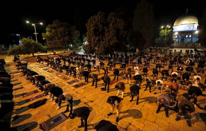  Penduduk Palestin solat Subuh berjemaah dengan norma baharu penjarakan sosial dalam pekarangan Masjid al-Aqsa berlatarbelakangkan Kubah Batu di Kota Lama Baitulmaqdis, semalam. — Gambar AFP