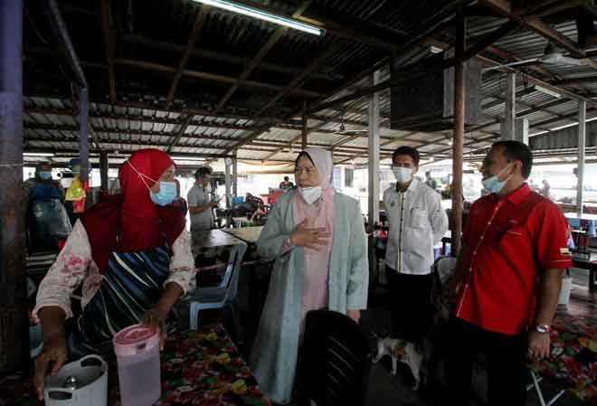  Zuraida (tiga kanan) menerangkan berkaitan menaik taraf gerai kepada peniaga Asmah Ahmad 59, (kiri) ketika meninjau tapak menaik taraf Gerai Rakyat di Pekan Langkap, Teluk Intan semalam. — Gambar Bernama