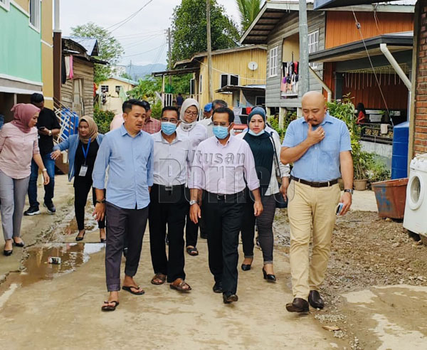  Azhar (tengah) bersama rombongan ketika meninjau keadaan penduduk kampung berkenaan yang terjejas banjir.