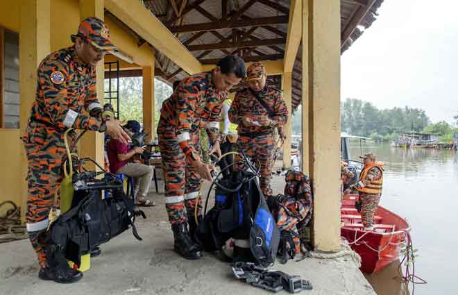  Mohd Farid (kiri) bersama anggotanya membuat persiapan sebelum meneruskan operasi mencari dan menyelamat mangsa bot karam yang masih hilang di muara Kuala Kemasin semalam. — Gambar Bernama 