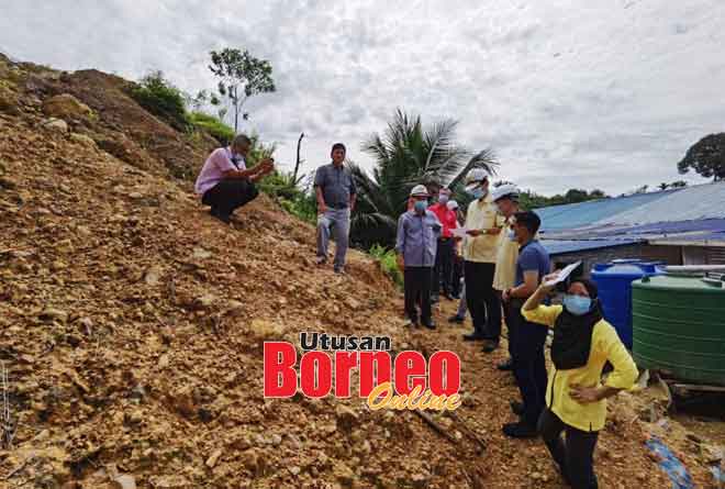  Talib (berdiri, dua kiri), pihak JKR dan rombongan meninjau perkembangan projek bina baharu penghadang tanah runtuh dan sistem perparitan di Rumah Muhan.