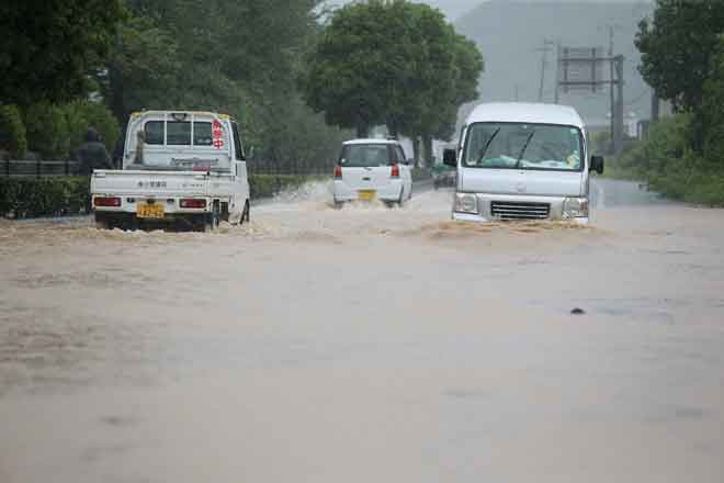  Kenderaan melalui jalan yang ditenggelami banjir akibat hujan lebat di Yatsushiro, wilayah Kumamoto, Jepun semalam. — Gambar AFP