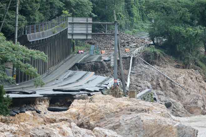  Sebatang jalan terputus akibat banjir dan tanah runtuh yang dicetuskan hujan lebat dekat sungai Kuma di Ashikita, Kumamoto semalam. — Gambar AFP