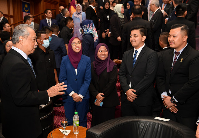 Muhyiddin (kiri) beramah mesra bersama sebahagian daripada 82 peserta Felo Perdana pada Majlis Penyerahan Felo Perdana kepada Barisan Jemaah Menteri di Bangunan Perdana Putra hari ini. - Gambar Bernama 